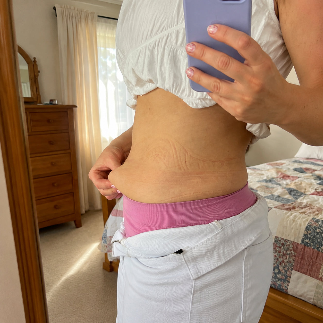 Woman in profile showing her postpartum belly